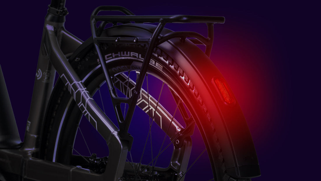 Close-up of a bicycle wheel with a red light on a dark background